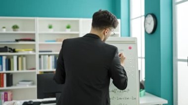 Genç Arap erkek öğretmen üniversite sınıfında matematik dersi veriyor.