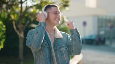 Young hispanic man smiling confident listening to music at park