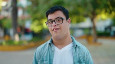 Down sendromlu adam parkta kendinden emin bir şekilde duruyor.