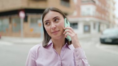 Genç İspanyol kadın gülümsüyor. Kendine güveniyor. Akıllı telefondan konuşuyor.