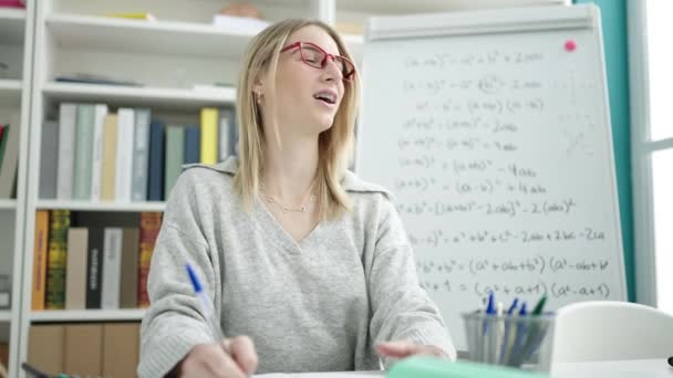 Joven Mujer Rubia Enseñando Matemáticas Sentado Escritorio Biblioteca Universidad — Vídeos de Stock