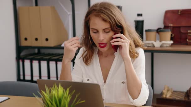 Genç Güzel Spanyol Kadını Ofiste Bilgisayarla Akıllı Telefondan Konuşuyor — Stok video