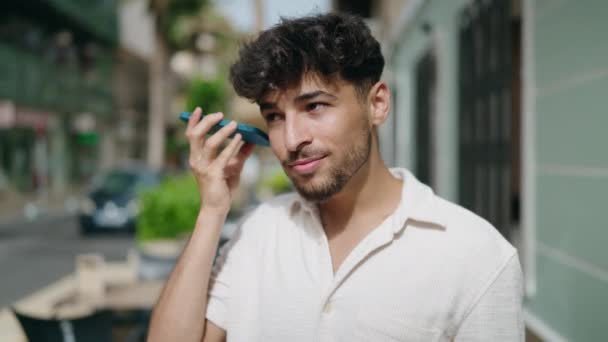 年轻的阿拉伯人微笑着 自信地听着街上智能手机发出的音频信息 — 图库视频影像