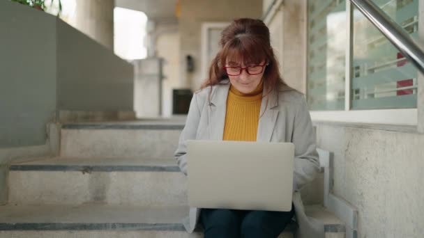 Жінка Середнього Віку Керівник Бізнесу Використовуючи Ноутбук Сидить Сходах Вулиці — стокове відео