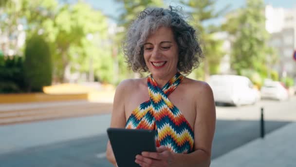 Mujer Pelo Gris Mediana Edad Sonriendo Confiada Usando Touchpad Calle — Vídeo de stock
