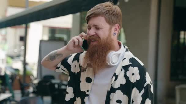 Ung Rödhårig Man Ler Tryggt Talar Smartphone Kafé Terrass — Stockvideo