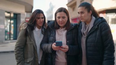 Anne ve kızları sokakta akıllı telefon kullanırken şaşırdılar.