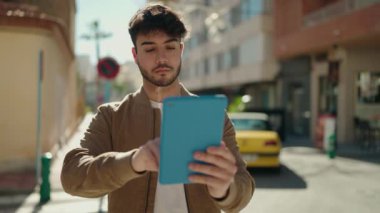 Sokakta dokunmatik ped kullanan, kendine güvenen İspanyol genç adam.