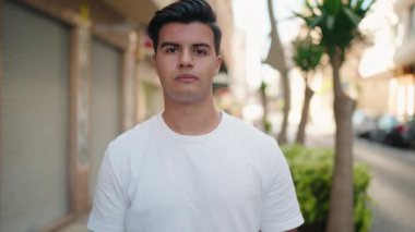 Sokakta kendinden emin gülümseyen İspanyol genç adam.