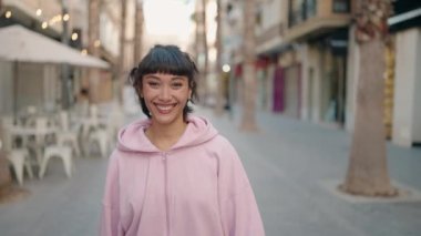 Sokakta kendine güvenen genç İspanyol kadın gülümsüyor