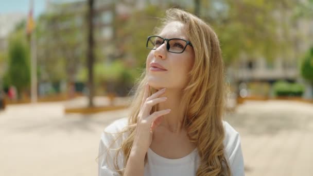 Parkta Şüpheli Bir Ifadeyle Duran Gözlüklü Genç Sarışın Kadın — Stok video