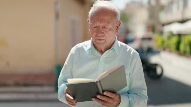 Orta Yaşlı Kır Saçlı Sokakta Kitap Okuyan Bir Adam — Stok video