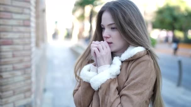 Junge Blonde Frau Bläst Bei Kälte Auf Der Straße Luft — Stockvideo