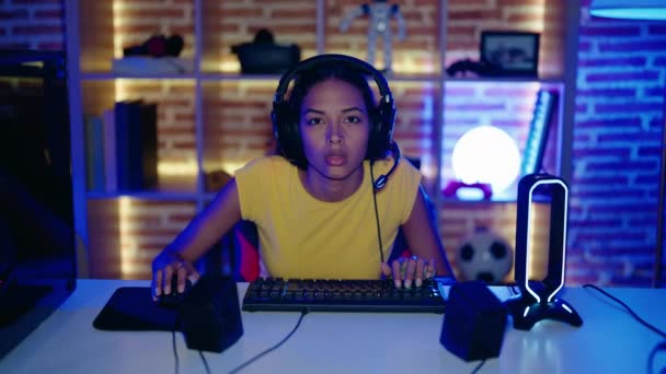 若いアフリカ系アメリカ人女性のストリーマーは ゲームルームで勝者の式でビデオゲームをプレイ — ストック動画