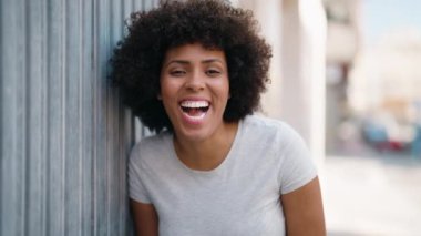 Genç Afrikalı Amerikalı kadın gülümsüyor. Kendine güveni tam.