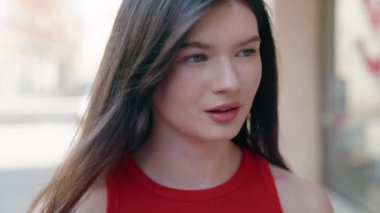 Beyaz kadın gülümsüyor. Kendinden emin. Caddenin kenarına bakıyor.