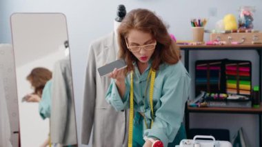 Terzide akıllı telefondan konuşan güzel İspanyol kadın.