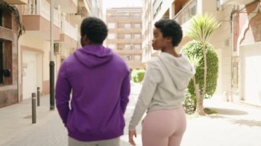 African american man and woman sporty couple standing with arms crossed gesture at street