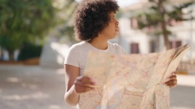 Young african american woman looking city map at park