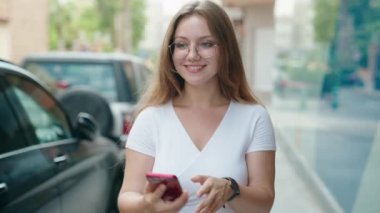 Genç sarışın kadın gülümsüyor. Kendine güveni tam.