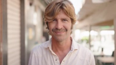 Sokakta kendine güvenen genç adam gülümsüyor