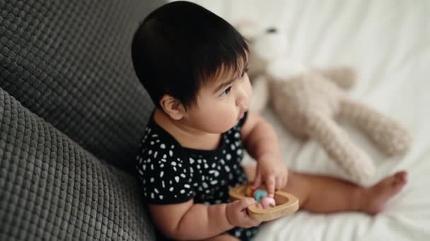 Sevimli Spanyol Bebek Elinde Çıngırakla Kanepede Oturuyor — Stok video