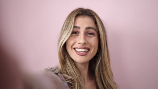 Joven Mujer Rubia Sonriendo Confiada Teniendo Videollamada Sobre Fondo Rosa — Vídeo de stock