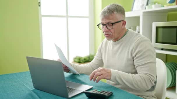 Mężczyzna Średnim Wieku Siwe Włosy Pomocą Laptopa Czytania Dokumentu Domu — Wideo stockowe