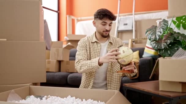 Jovem Árabe Homem Sorrindo Confiante Desembalagem Caixa Papelão Nova Casa — Vídeo de Stock