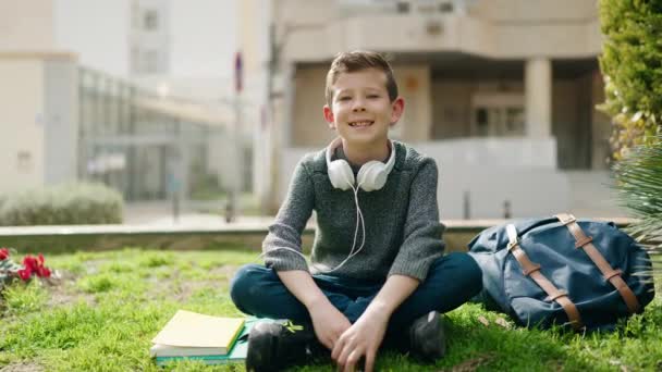 Sarışın Çocuk Merhaba Diyor Parkta Çimlerde Oturuyor — Stok video