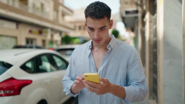 Νεαρός Ισπανόφωνος Χρησιμοποιώντας Smartphone Την Έκφραση Νικητής Στο Δρόμο — Αρχείο Βίντεο