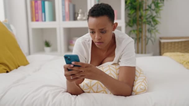 Mujer Afroamericana Usando Smartphone Con Expresión Preocupada Dormitorio — Vídeo de stock