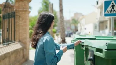 Genç İspanyol kız gülümsüyor. Sokakta geri dönüşüm plastiği.