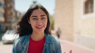 Sokakta kendine güvenen genç İspanyol kız gülümsüyor.