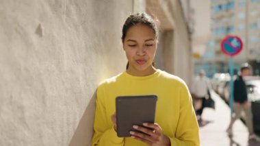 Sokakta dokunmatik ped kullanan, kendine güvenen genç Afro-Amerikan kadın.