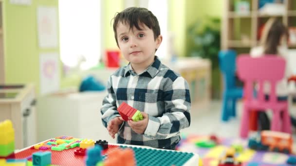 Adorable Hispanic Boy Playing Construction Blocks Standing Kindergarten — Stockvideo