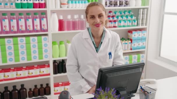Νεαρή Όμορφη Ισπανίδα Φαρμακοποιός Χαμογελώντας Αυτοπεποίθηση Χρησιμοποιώντας Υπολογιστή Στο Φαρμακείο — Αρχείο Βίντεο