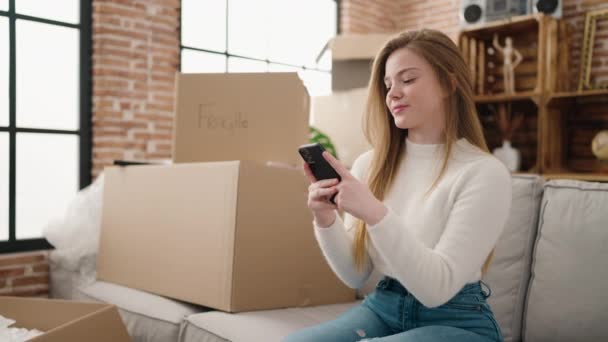 Young Blonde Woman Smiling Confident Using Smartphone New Home — Vídeo de Stock