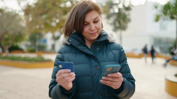 在公园使用智能手机和信用卡的中年妇女 — 图库视频影像