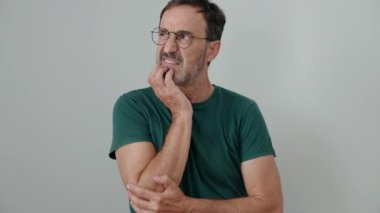 İzole edilmiş beyaz arka planda şüpheli bir ifadeyle duran orta yaşlı bir adam.