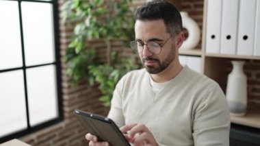 Ofiste çalışan İspanyol bir iş adamı dokunmatik ped kullanıyor.