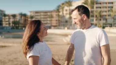 Man and woman couple hugging each other standing at beach