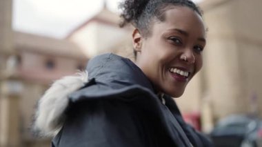 Sokakta kendine güvenen Afrikalı Amerikalı kadın gülümsüyor