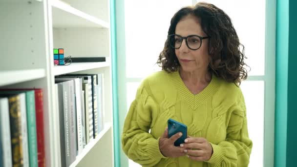 Moyen Âge Hispanique Enseignante Utilisant Smartphone Tenant Livre Bibliothèque Universitaire — Video