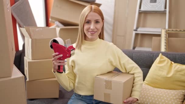 Young Blonde Woman Holding Package Packing Machine New Home — Stock Video