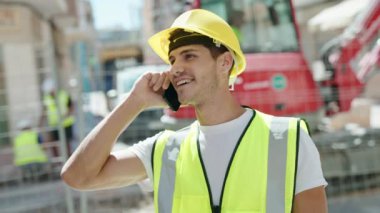 Genç İspanyol mimar gülümsüyor. Parkta akıllı telefondan konuşuyor.