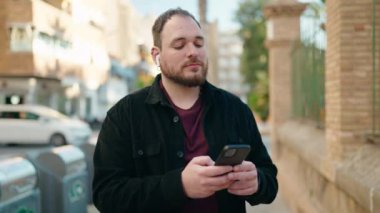 Young plus size man listening to music and dancing at street