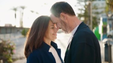 Man and woman couple standing together and kissing at street