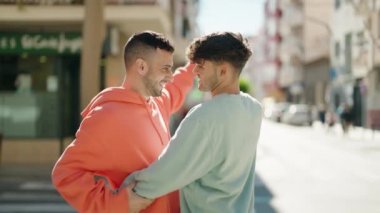 Genç İspanyol çift sokakta dans ederken gülümsüyor.