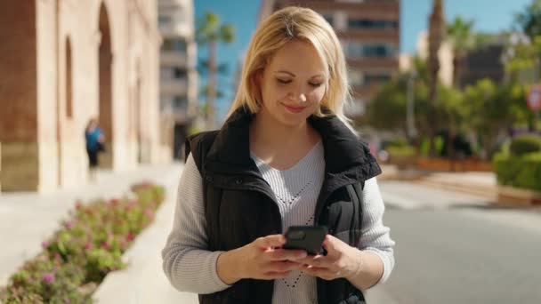 Молода Блондинка Посміхається Впевнено Використовуючи Смартфон Вулиці — стокове відео